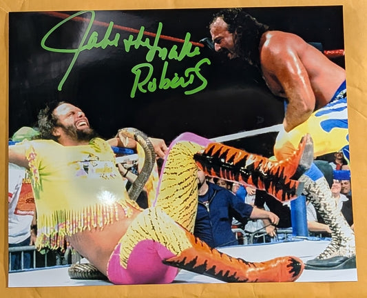 + Jake “The Snake” Roberts Signed WWE 8x10 Color Photo (Comes w/COA)