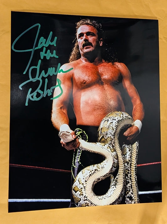 + Jake “The Snake” Roberts Signed WWE 8x10 Color Photo (Comes w/COA)